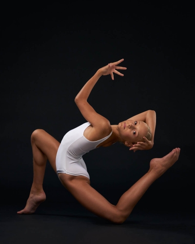 Contemporary dancer executing a powerful leap in the studio.