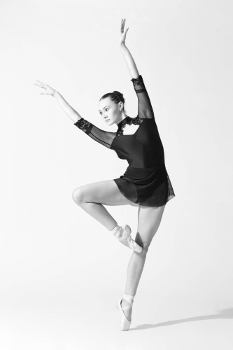 Contemporary dancer striking an elegant pose under studio lights.