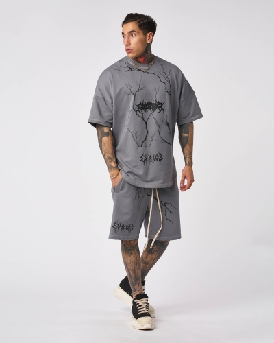 Tattooed model showcasing modern streetwear style in a professional studio photoshoot.